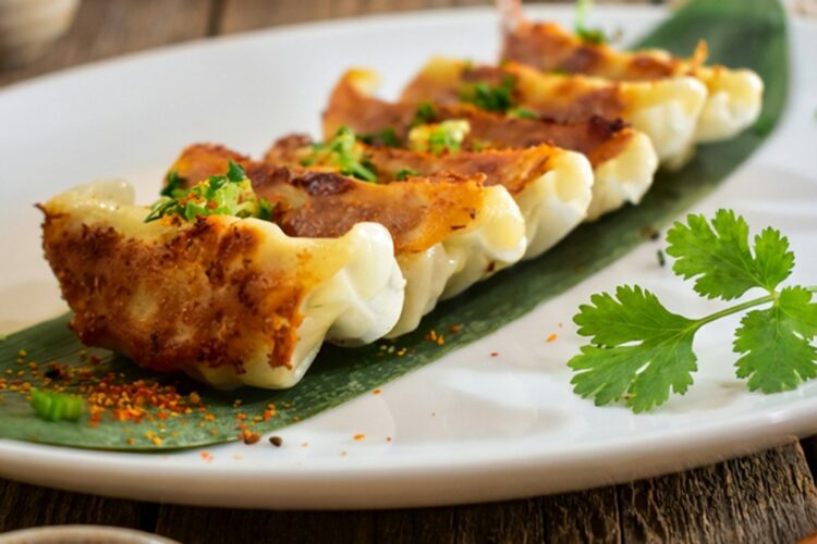 Golden pan-fried shrimp dumplings with crispy bottoms served on a plate