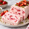 Sliced strawberry semifreddo loaf topped with fresh strawberries and chopped pistachios
